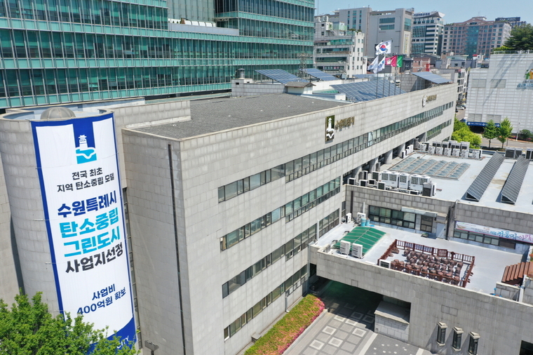 (사진제공/ 수원시) 수원시청사 외벽에 탄소중립 그린도시 사업 선정을 알리는 대형 현수막이 게시돼 있는 모습.