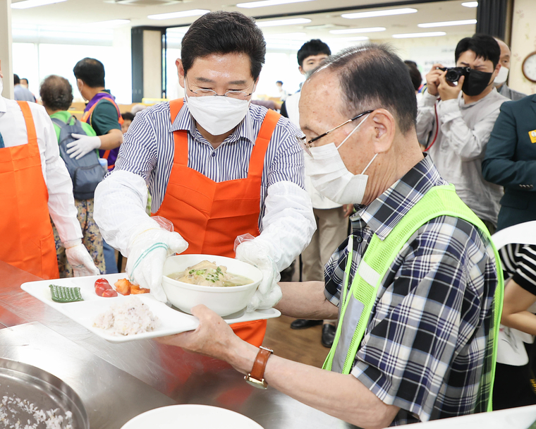  이상일 용인시장이 중복 맞이 삼계탕 나눔 행사에 참석해 한 어르신에게 삼계탕을 드리고 있다. (용인시청 제공)