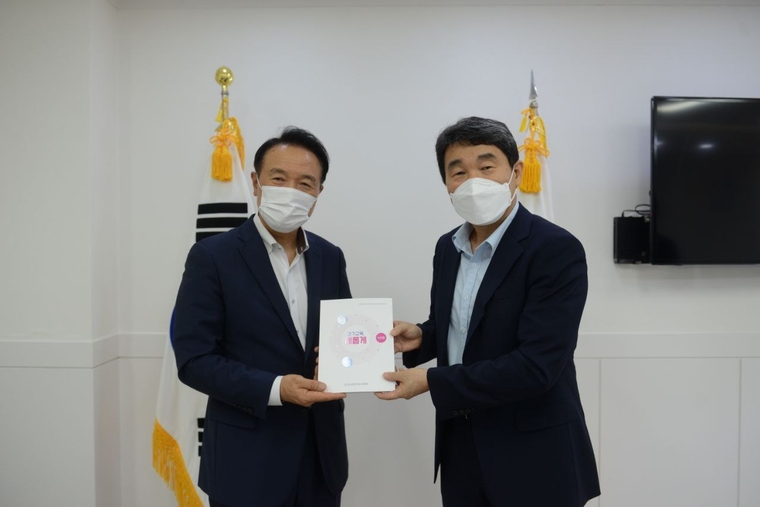 이주호위원장이 임태희 교육감에게 ‘주민직선 5기 경기도교육감직인수위원회 백서’를 전달하고 있다 (경기도교육청 제공)