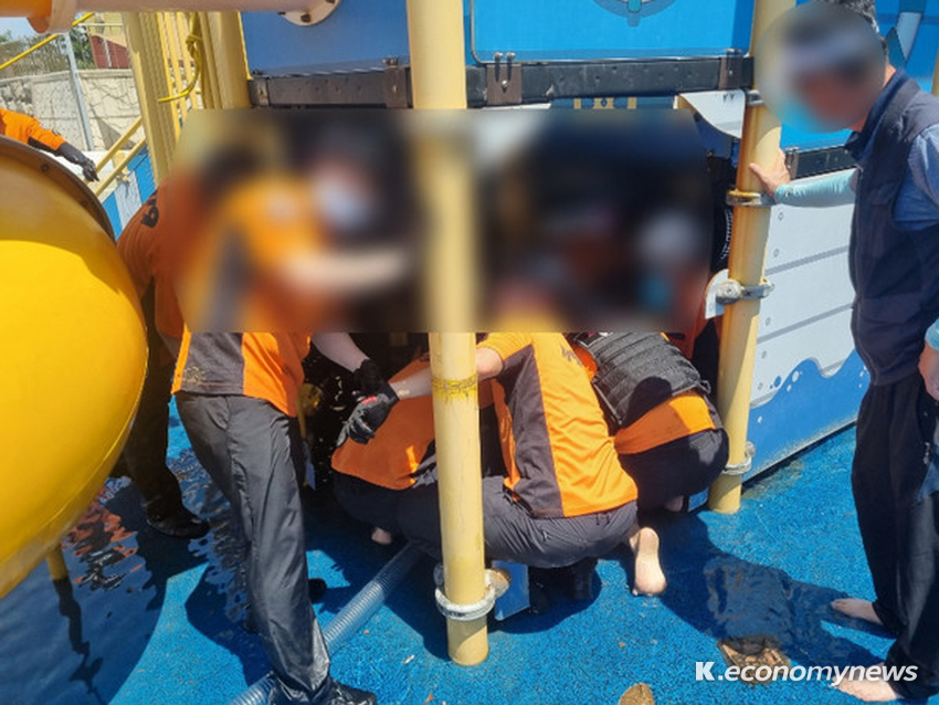  울릉도 어린이물놀이 시설에서 취수구에 팔이 끼여 있는 초등학생을 울릉119안전센터 대원이 구조하고 있다 <사진 = 포항남부소방서 제공>