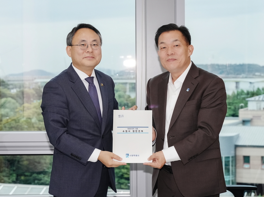 이재준 시장(오른쪽)이 건의 내용을 담은 책자를 고기동 차관(왼쪽)에게 전달하고 있다 <수원시 제공>