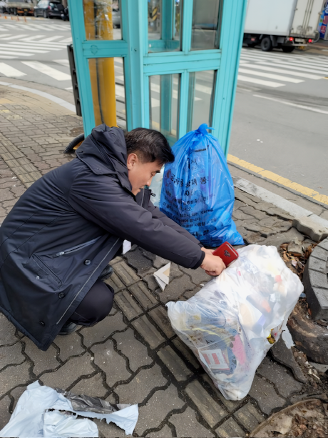 수원시 깨끗한 쓰레기처리 감시원이 무단 배출된 생활폐기물을 살펴보고 있는 모습 <수원시 제공>