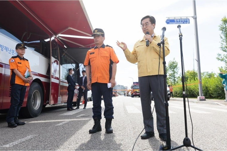 김동연 경기도지사가 화성시 일차전지 제조업체 화재 발생 2일차인 25일, 공장화재 현장 인근에서 소방재난본부장과 함께 언론 브리핑을 하고 있다 <경기도 제공>