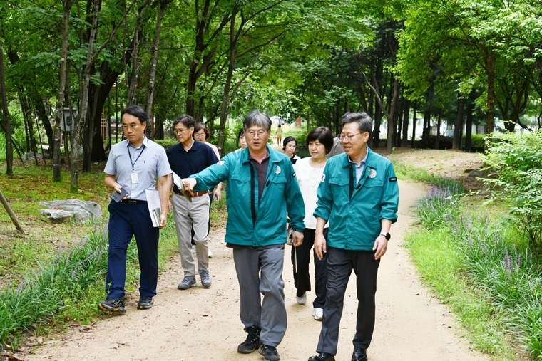 박사승 구청장(사진 앞줄 오른쯕)과 직원들이 폭염도 뒤로하고 머내생태공원을 살펴보고 있다 <수원시 영통구 제공>