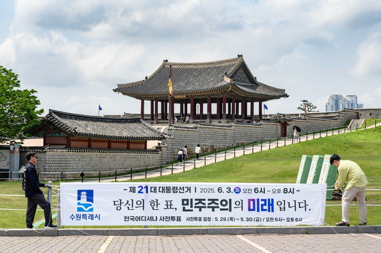 투표 참여를 독려하는 문구가 적힌 현수막을 설치하고 있는 모습 <수원시 제공>