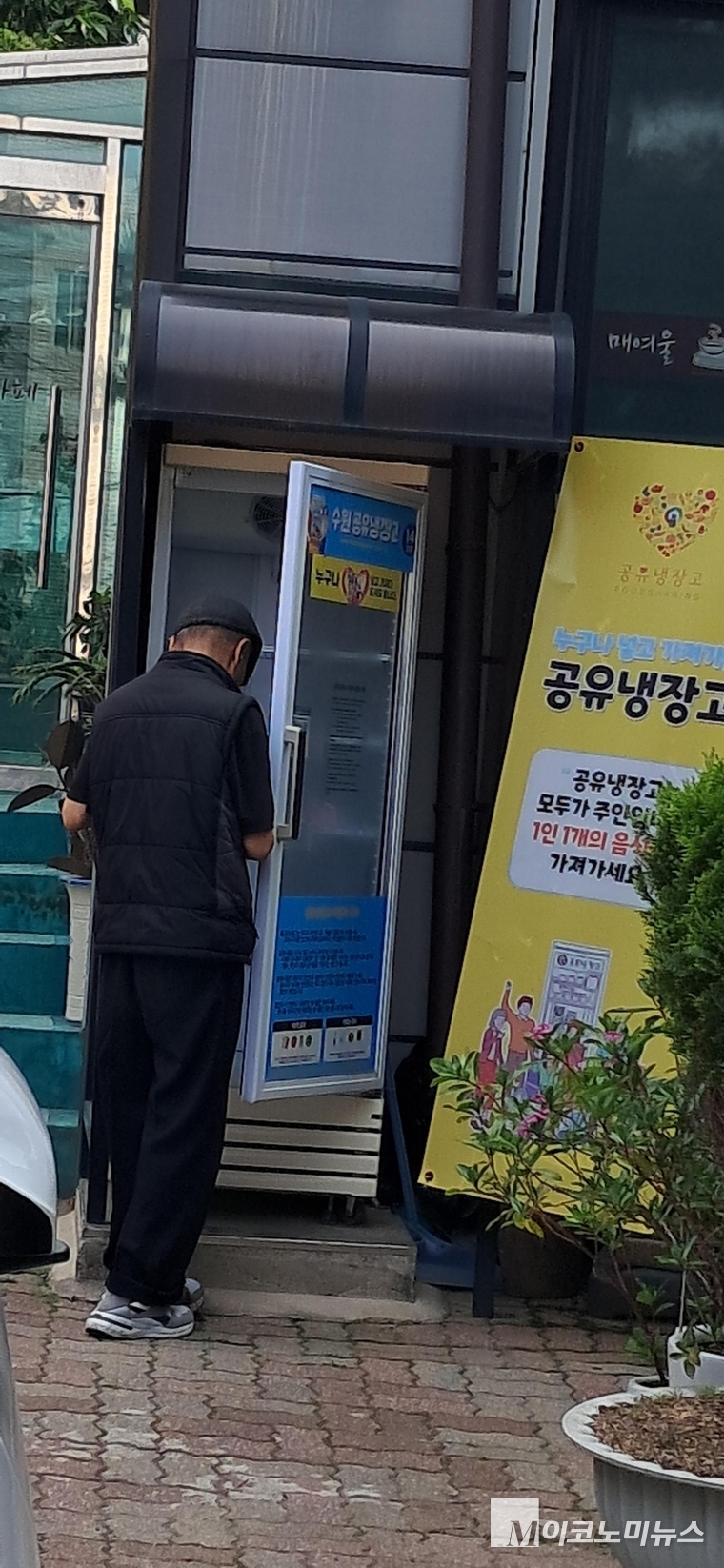 공유 냉장고에서 물품을 꺼내가고 있는 시민 모습 <안자영 기자> 